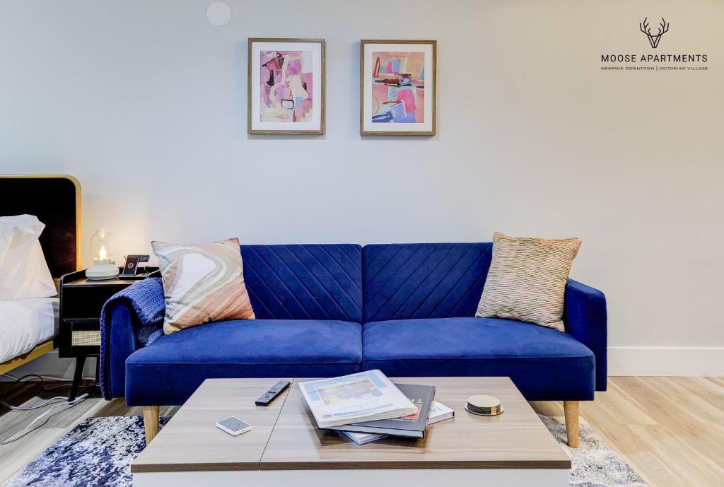 Sofá azul en la sala de estar con mesa de centro en The Moose #9 - Brand New Luxe Modern loft with Free Parking, King Bed & Fast WiFi en Memphis