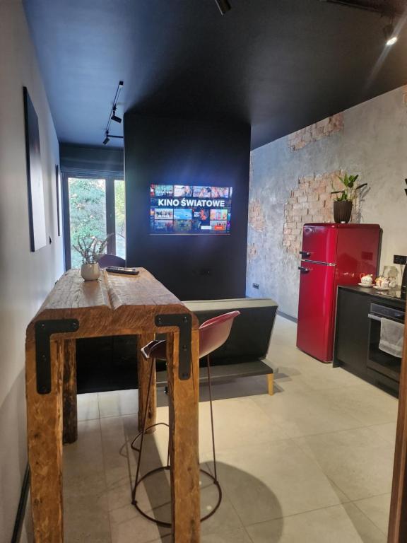 Il comprend une cuisine équipée d'une table en bois et d'un réfrigérateur rouge. dans l'établissement Loft vistula old town apartament free parking, à Cracovie