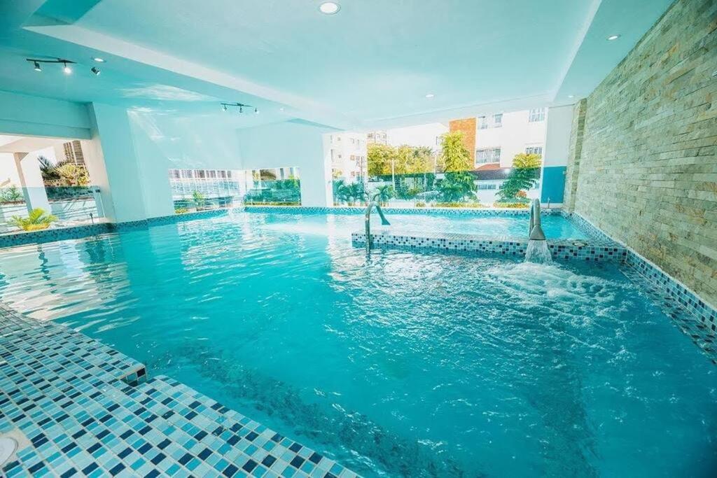 una piscina con acqua blu in un edificio di Stylish 1br Apt in Piantini/Serralles, Santo Dgo a Santo Domingo