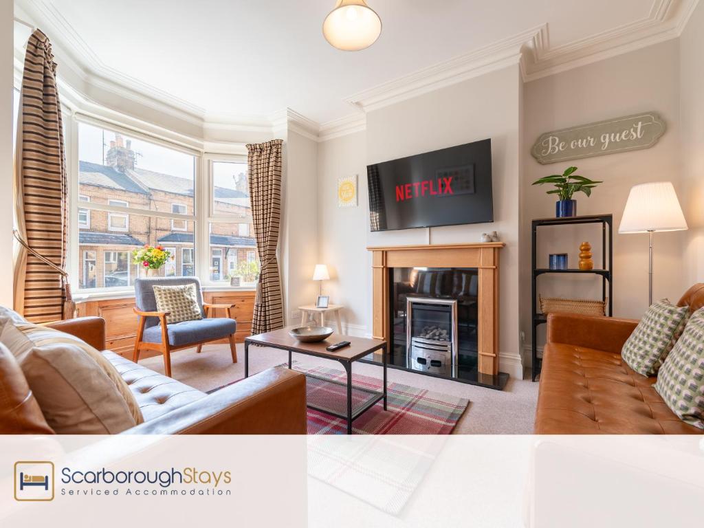 a living room with a couch and a fireplace at Mayville Lodge - STUNNING 3 BEDROOMED TOWNHOUSE WITH FREE PARKING in Scarborough