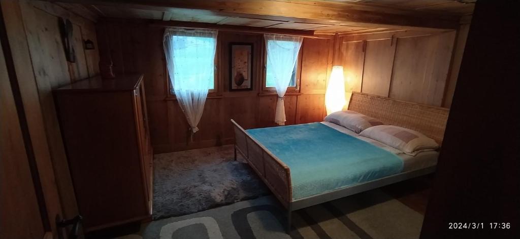 Dormitorio pequeño con cama y lámpara en Dom wiejski Artur, en Goldingen