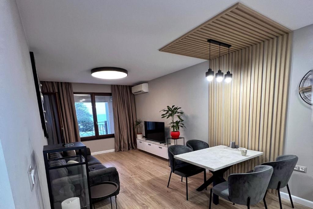 een woonkamer met een eettafel en stoelen bij Golden Sand Nelly apartment first line beach in Goudstrand