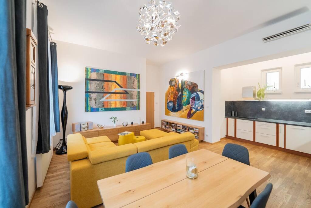 uma sala de estar com um sofá amarelo e uma mesa em Apartmán Praha Žižkov - DZ RENT em Praga
