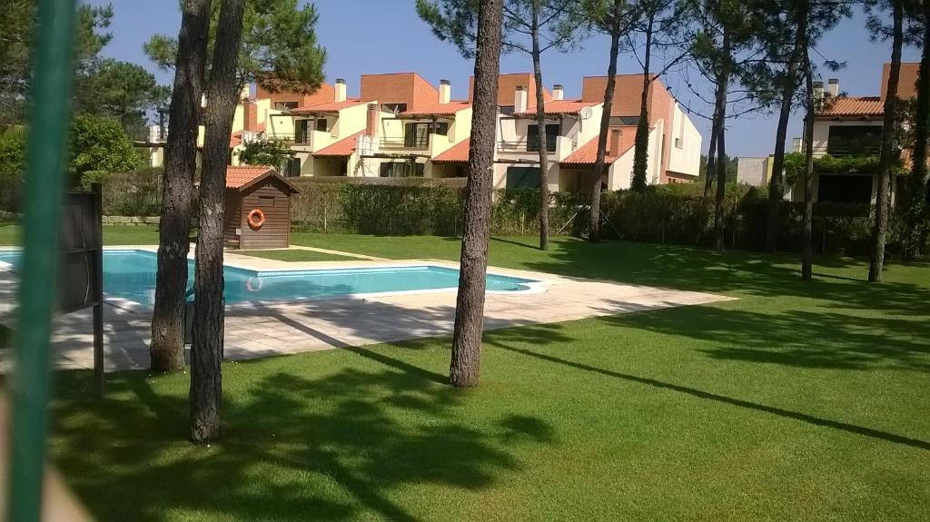 a house with a swimming pool in a yard with trees at Buganvilias House in Praia de Mira