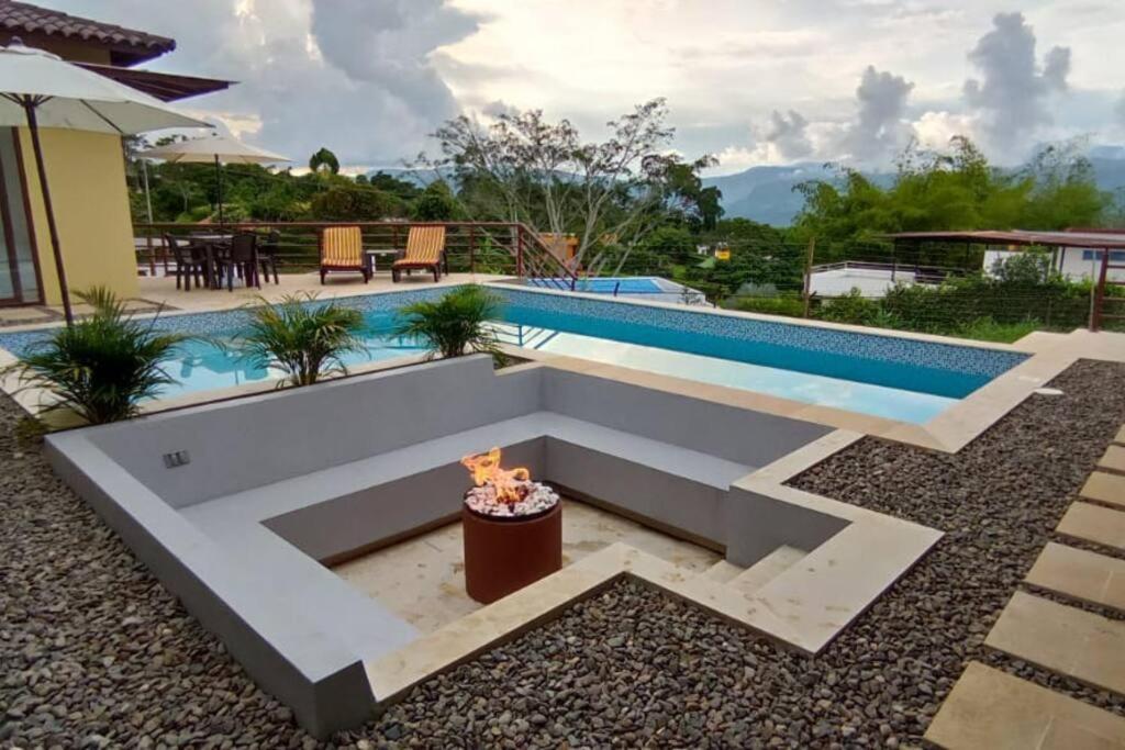 einen Pool mit einer Bank vor einem Haus in der Unterkunft Hermosa y Moderna Casa Campestre in La Mesa