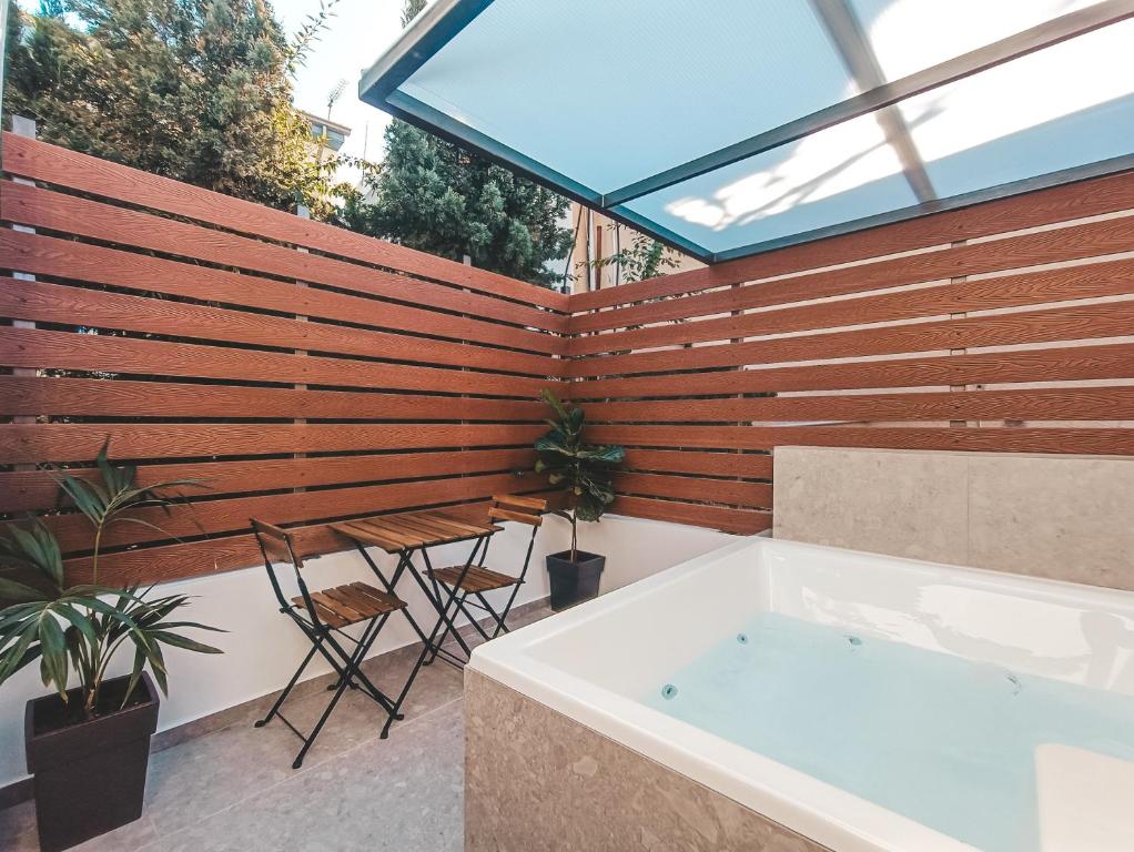 uma casa de banho com uma banheira e uma parede de madeira em The Secret Yard em Lárnaca