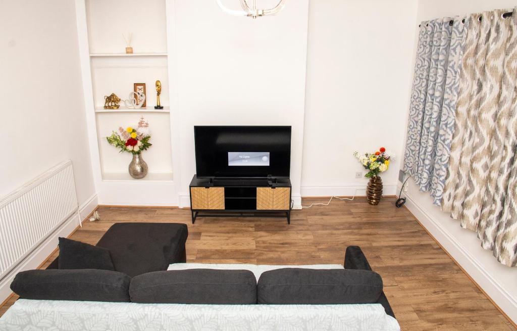 a living room with a couch and a tv at Luxury 2 bed flat in Northampton in Northampton