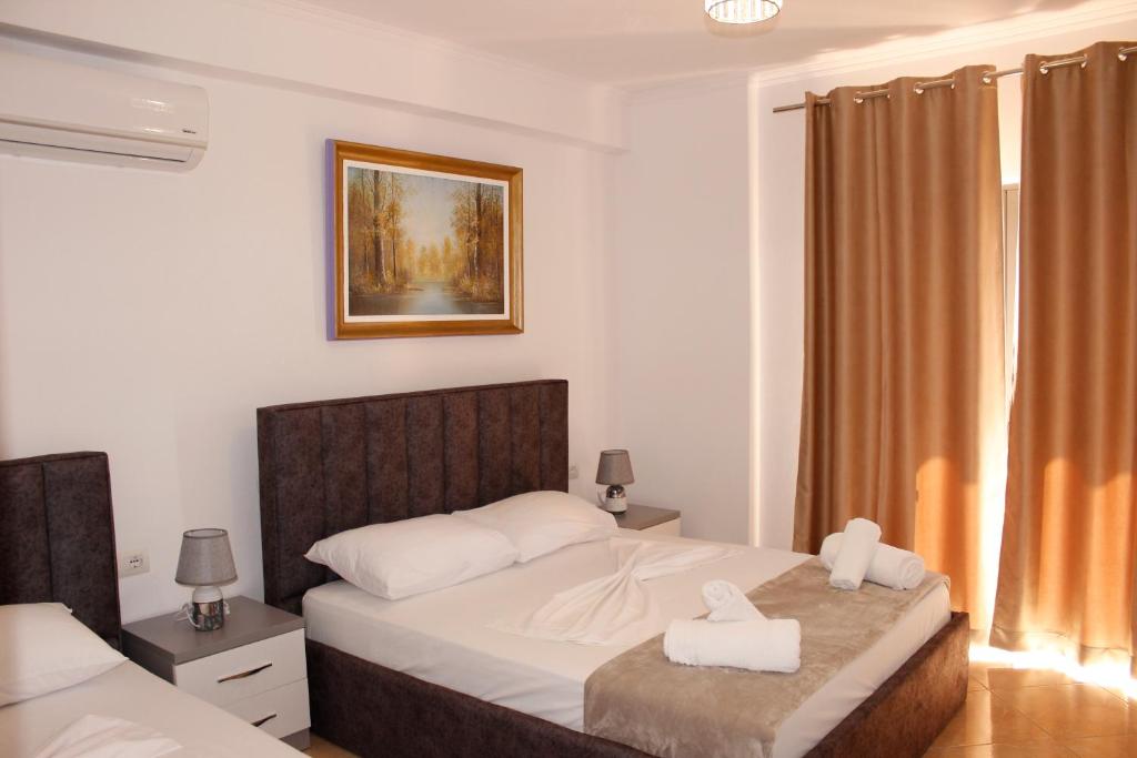 um quarto com uma cama com duas toalhas em ElMar Apartments em Saranda
