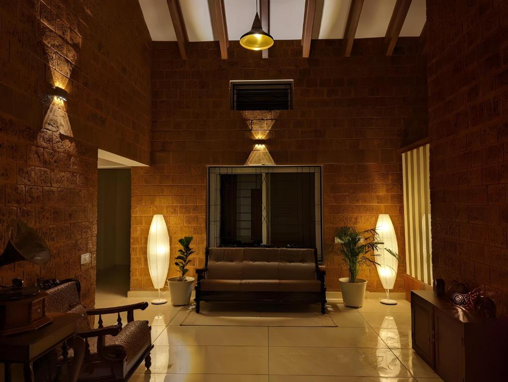 a living room with a couch in a brick wall at Red Rock Villa, Virajpet, Coorg in Virajpet