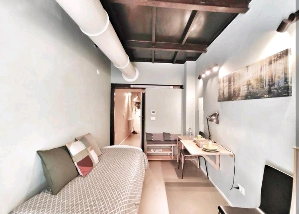 Cette chambre comprend un canapé, un bureau et une table. dans l'établissement Loft in pieno centro storico, à Reggio d'Émilie