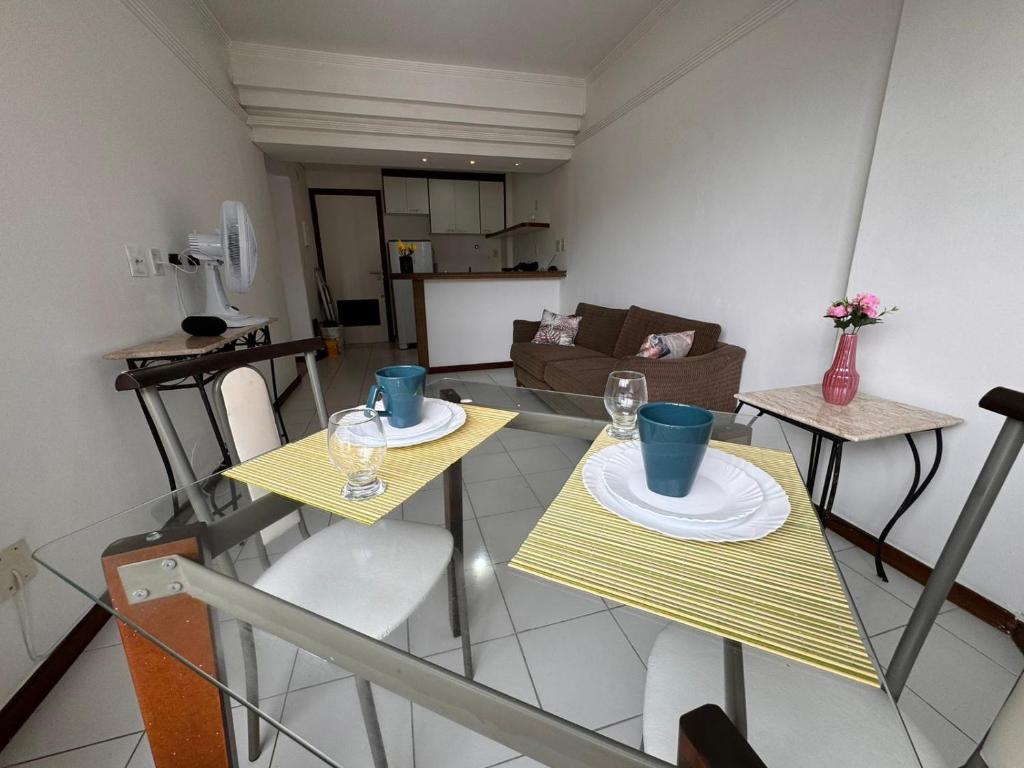 uma sala de estar com duas mesas e um sofá em Pituba sol flat em Salvador