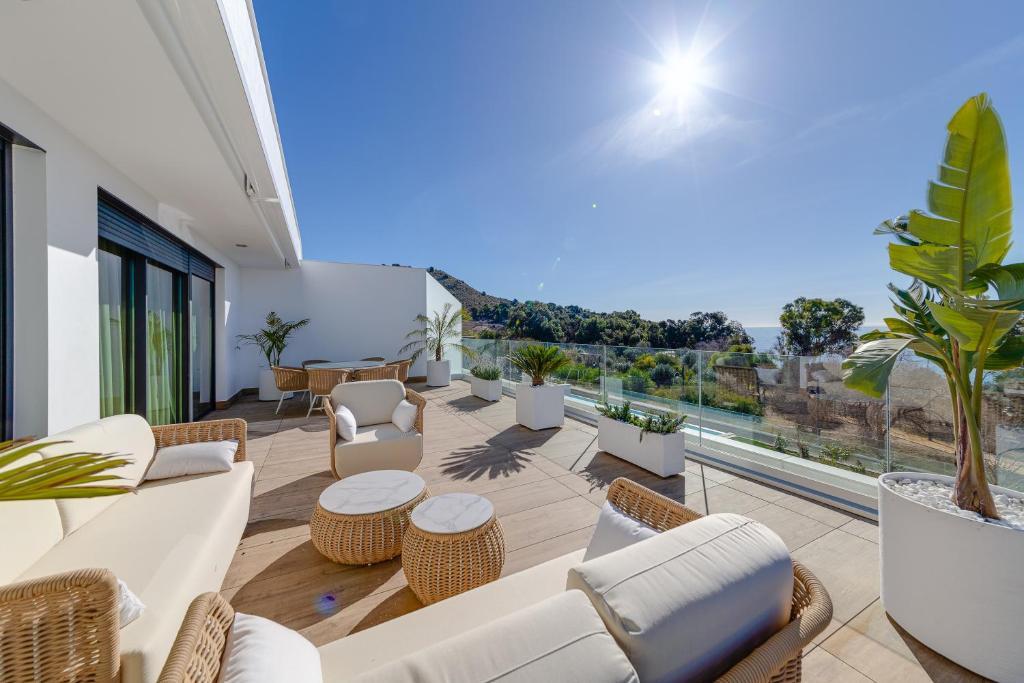Elle comprend une terrasse dotée d'un mobilier blanc et offrant une vue sur l'océan. dans l'établissement Lovely Oasis Or Ange - Exclusive, à La Vila Joiosa