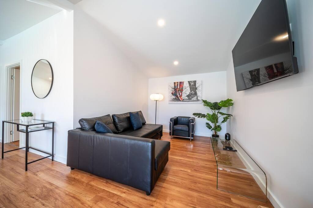 ein Wohnzimmer mit Sofa und Tisch in der Unterkunft Neptune - 2BR Private Pool WiFi in Thebarton
