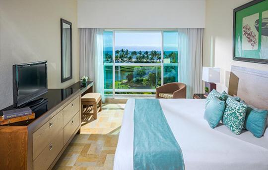 a hotel room with a large bed and a television at Vidanta Riviera Maya - Mayan Palace, Grand Mayan in Puerto Morelos