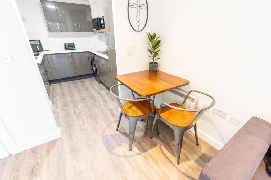 uma mesa de jantar e cadeiras numa cozinha em Modern, spacious entire 1 bedroom apartment. em Londres