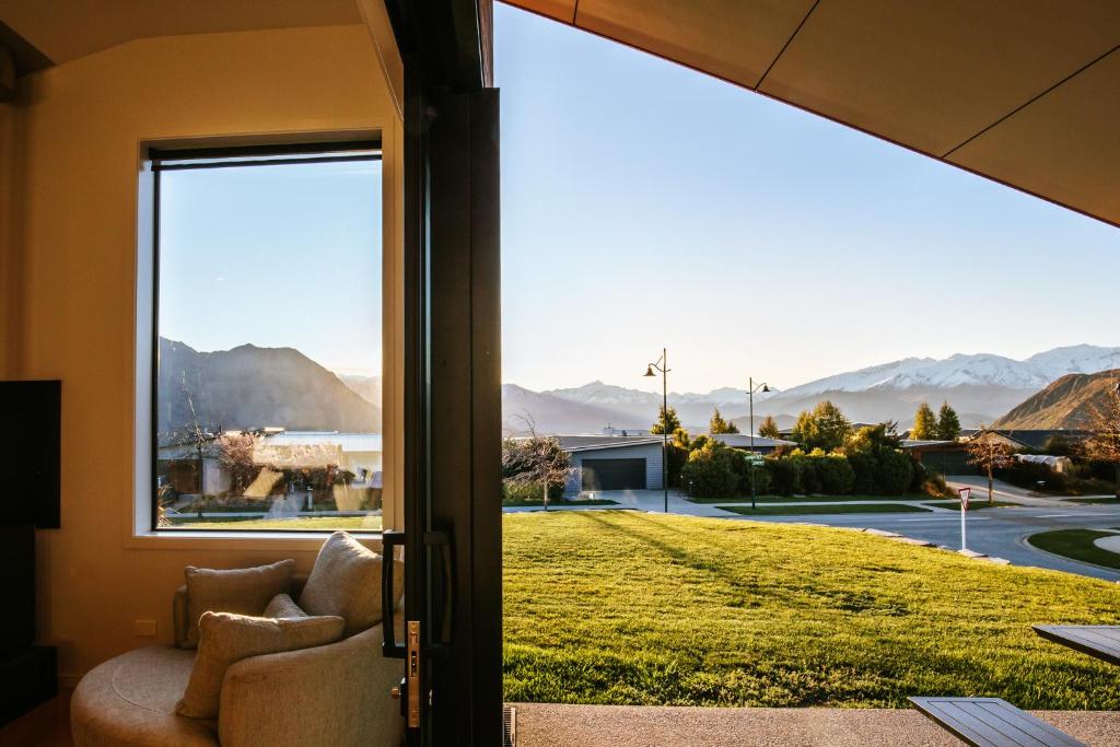 a room with a view of the mountains through a sliding glass door at On The Rocks - Sleeps 8 - Family Friendly Holiday Home in Paraparaumu Beach