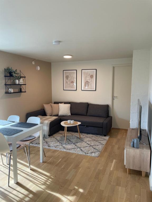 uma sala de estar com um sofá e uma mesa em Koselig og rolig leilighet med utsikt nær Preikestolen em Strand