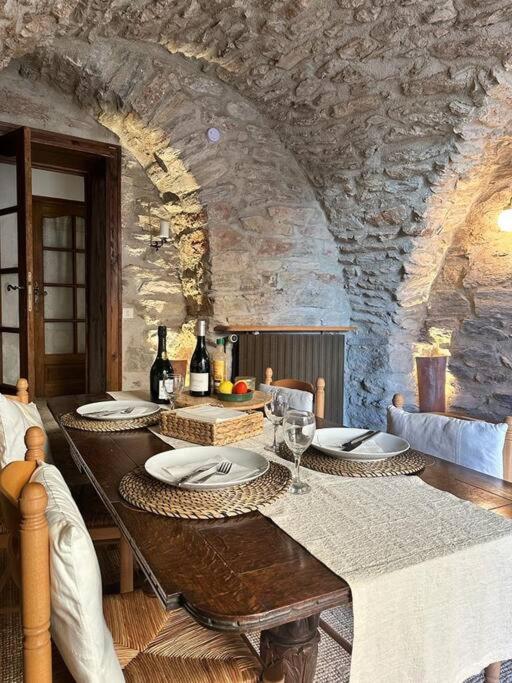 une salle à manger avec une table avec des assiettes et des verres à vin dans l'établissement 13th Century Stone House, à Faugères
