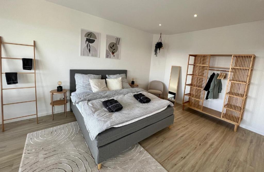- une chambre avec un lit dans un dortoir doté de parquet dans l'établissement PISO SUPERIOR - Exklusives Apartment an der Promenade mit Rheinsicht & Loggia, à Emmerich