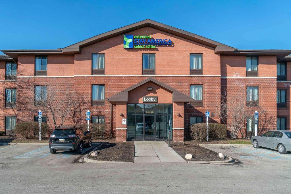 a large red brick building with a parking lot at Extended Stay America Select Suites - Detroit - Warren in Warren