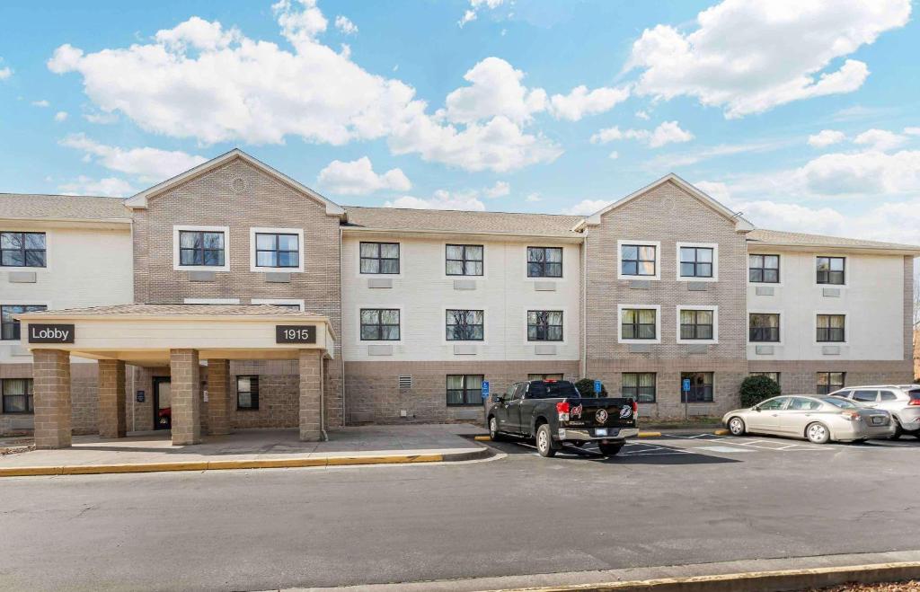 un gran edificio con coches estacionados en un estacionamiento en Extended Stay America Suites - Hampton - Coliseum en Hampton