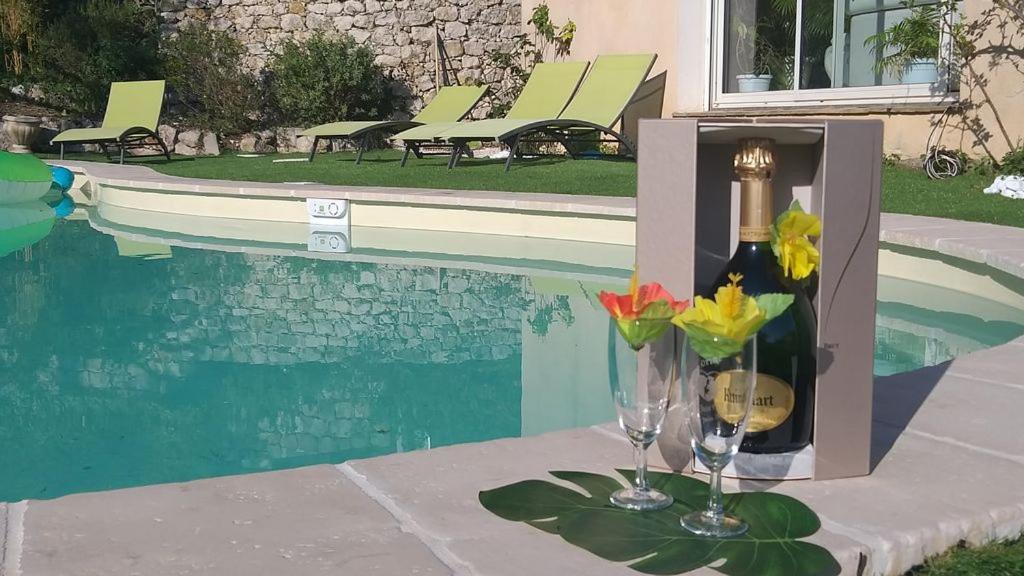 a bottle of wine and a glass next to a pool at l'Etoile de Nice in Colomars