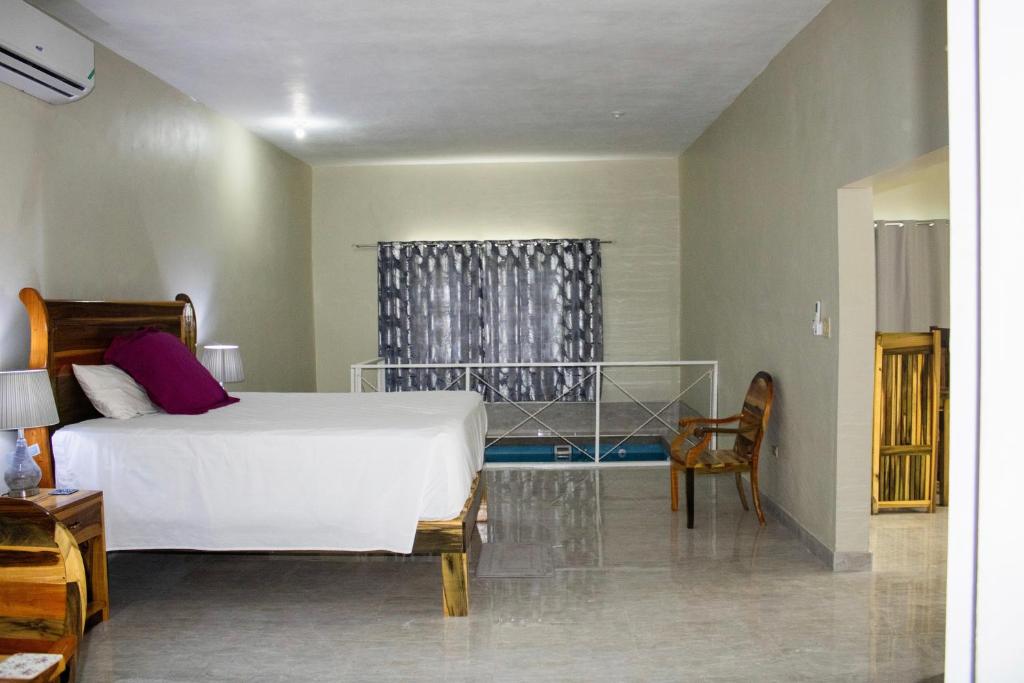 a bedroom with a white bed and a window at DEMAROYS in Treasure Beach