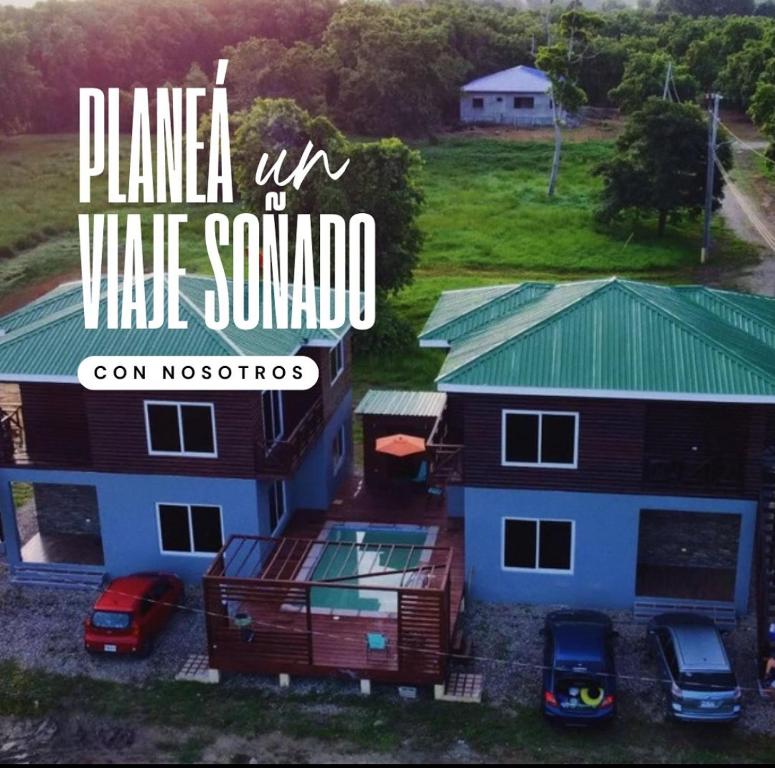 an aerial view of a house with cars parked in front at Cabañas Laguna Negra in Tela