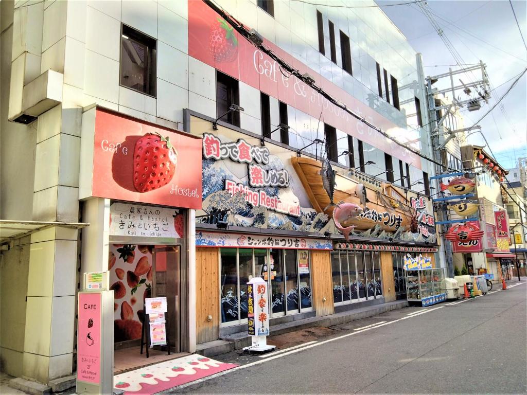 大阪Cafe&Hostel Kimi to Ichigo的街道一侧有标志的建筑