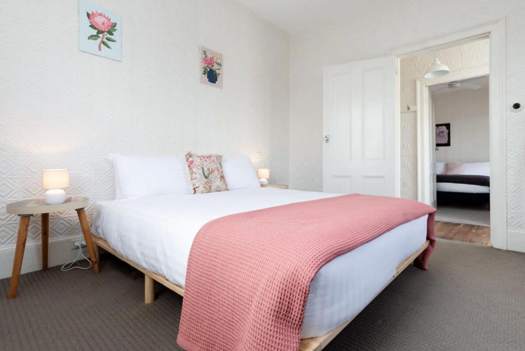 um quarto com uma cama grande e um cobertor rosa em What a Charmer: Near the CBD Parking & Wifi em Launceston