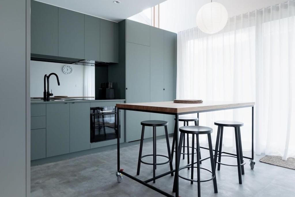 Una cocina con una mesa y taburetes en una habitación. en City Lights & Tiny Delights: Near CBD =& Parking, en Kings Park
