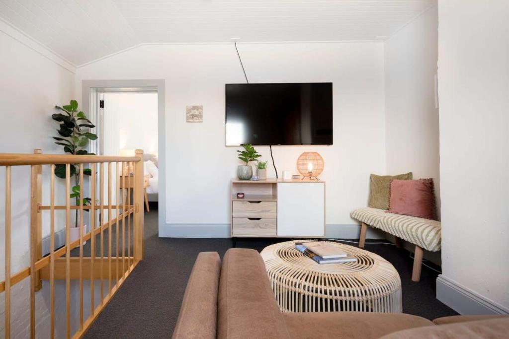 a living room with a couch and a tv at Little City Cottage with Free Onsite Parking in Launceston