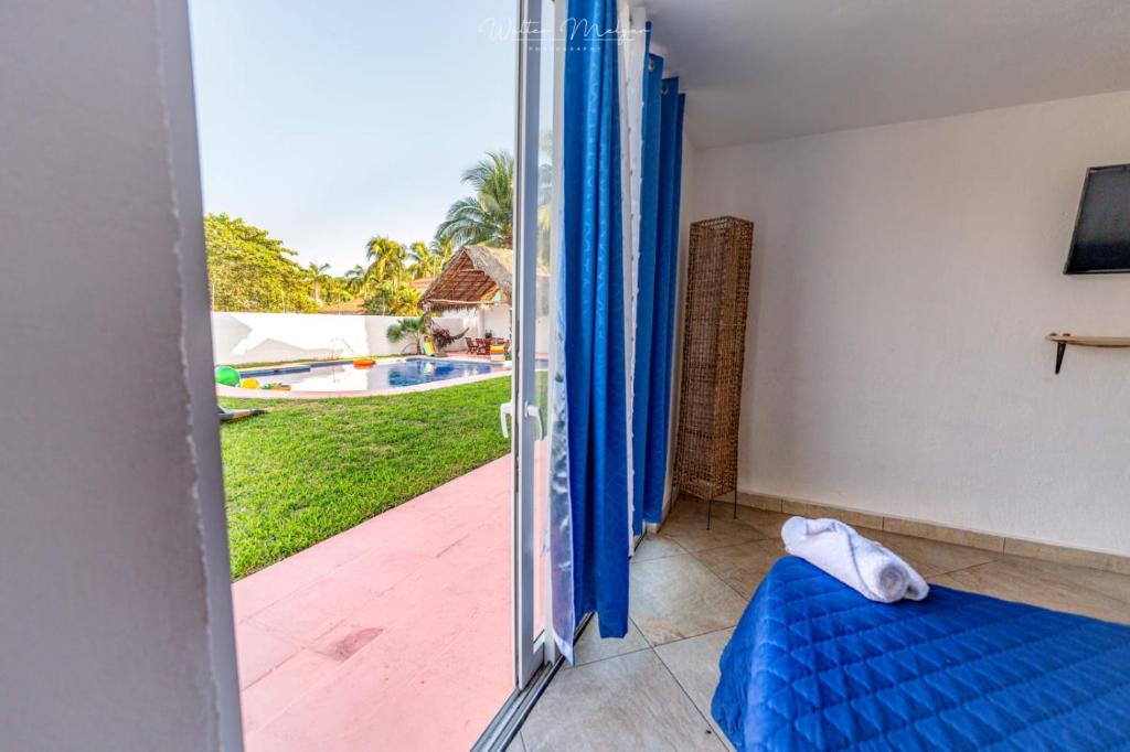 a room with a sliding glass door with a view of a pool at Casa Blanca in San José de Guatemala