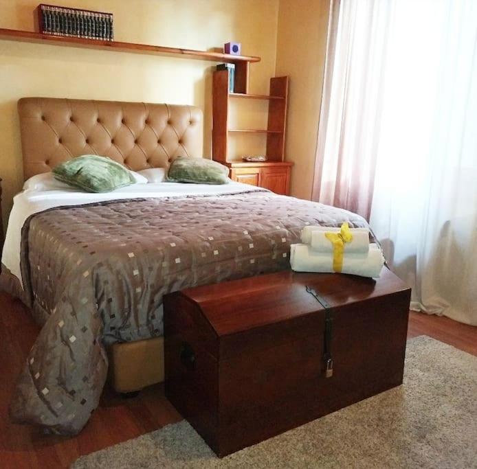 a bedroom with a large bed with a wooden trunk at GOLD HOUSE appartamento stazione centrale in Milan