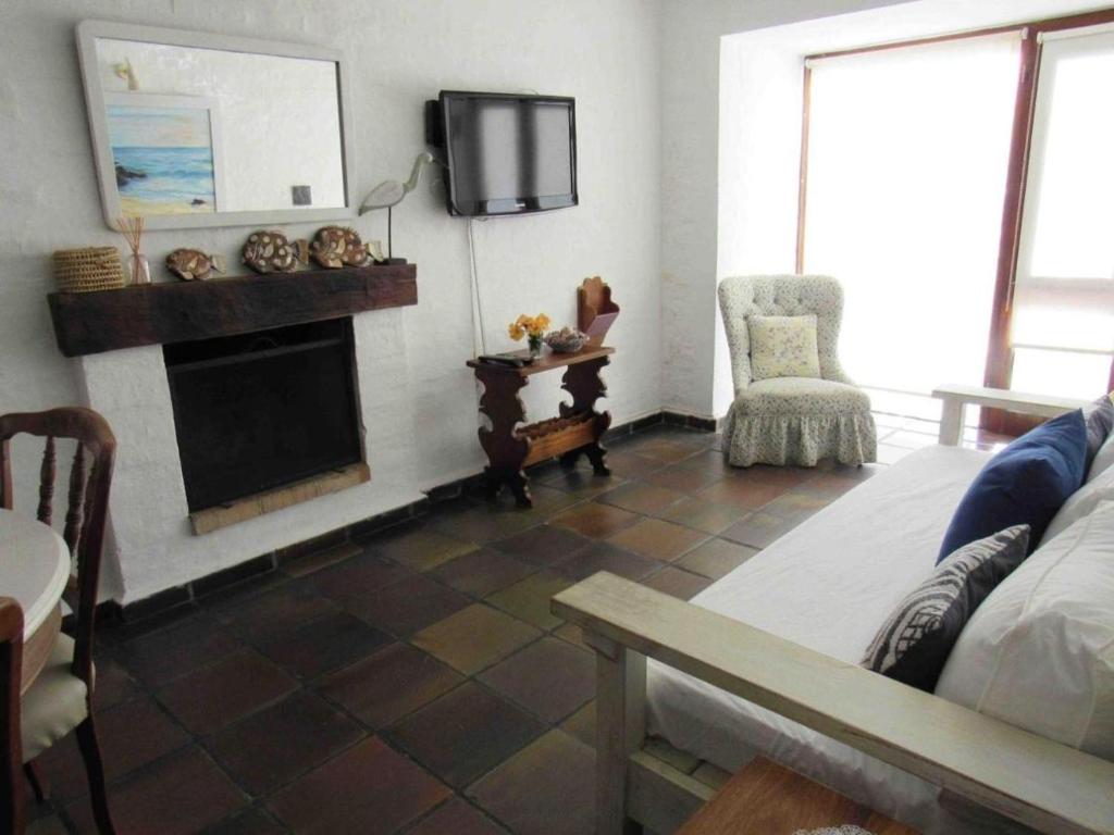 a living room with a fireplace and a tv at Resolana in Punta del Este