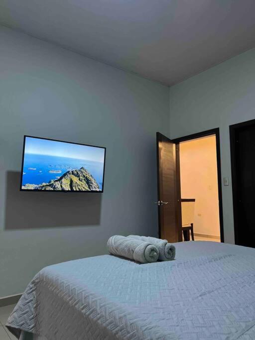 a bedroom with a bed with a tv on the wall at Casa moderna en catacamas in Catacamas