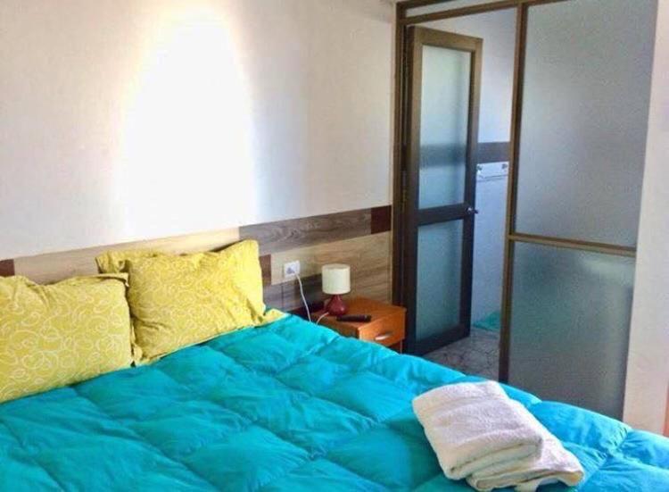 een slaapkamer met een blauw bed en een spiegel bij Mirador del valle in Arica