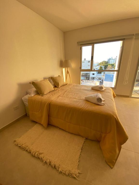 a bedroom with a large bed with a large window at Orillas II in Puerto Madryn