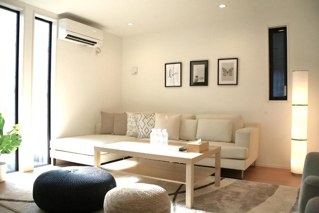 uma sala de estar com um sofá e uma mesa de centro em Casa Stella 2 Capricorn by Liaison em Osaka