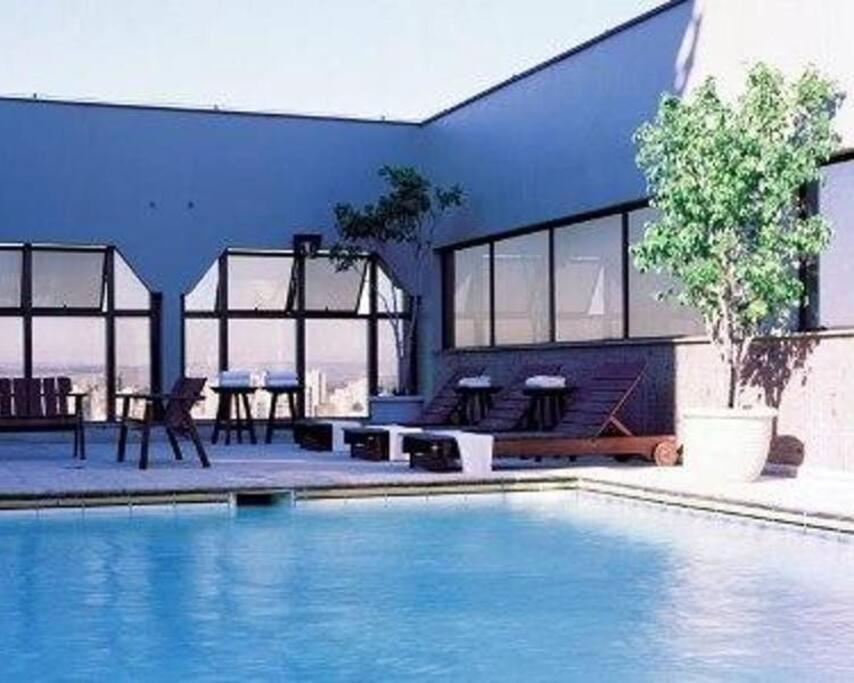 a blue house with a swimming pool and a table at Lindo Apto Flat Aconchegante e Mobiliado em Campinas !!! in Campinas