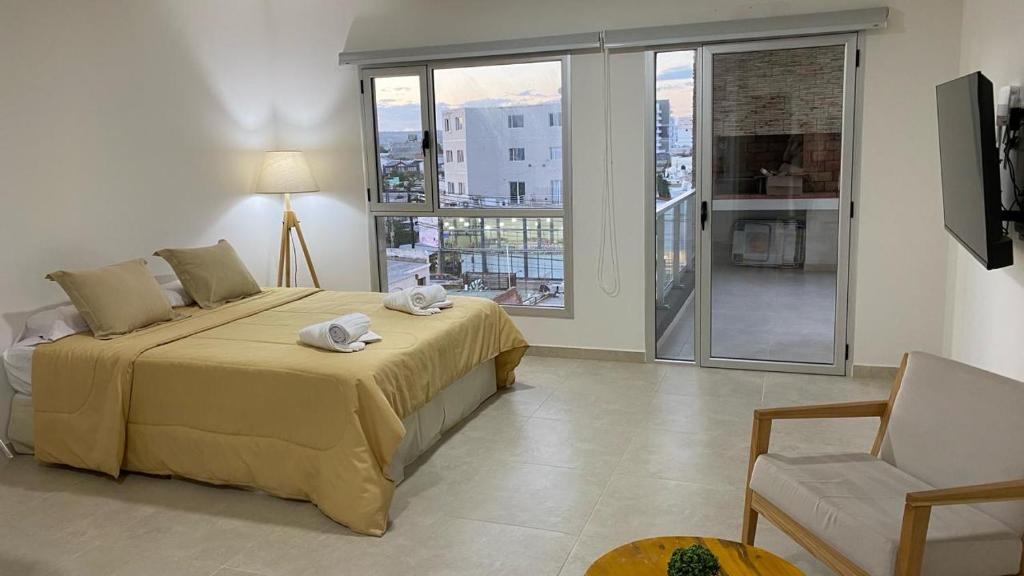 Un dormitorio con una cama con toallas. en Orillas II, en Puerto Madryn