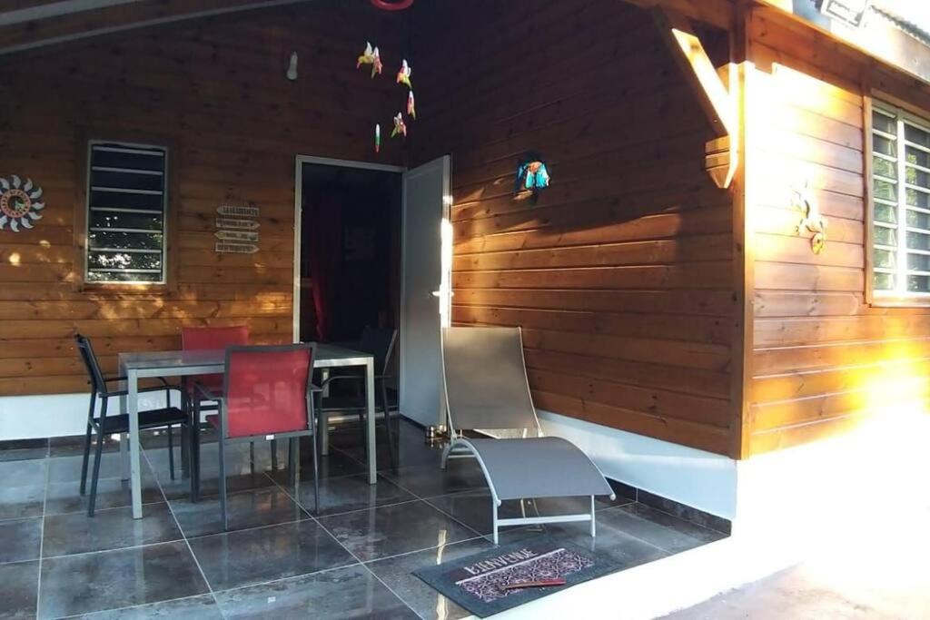 een patio met een tafel en stoelen voor een gebouw bij Villa Cachiman in Pointe-Noire