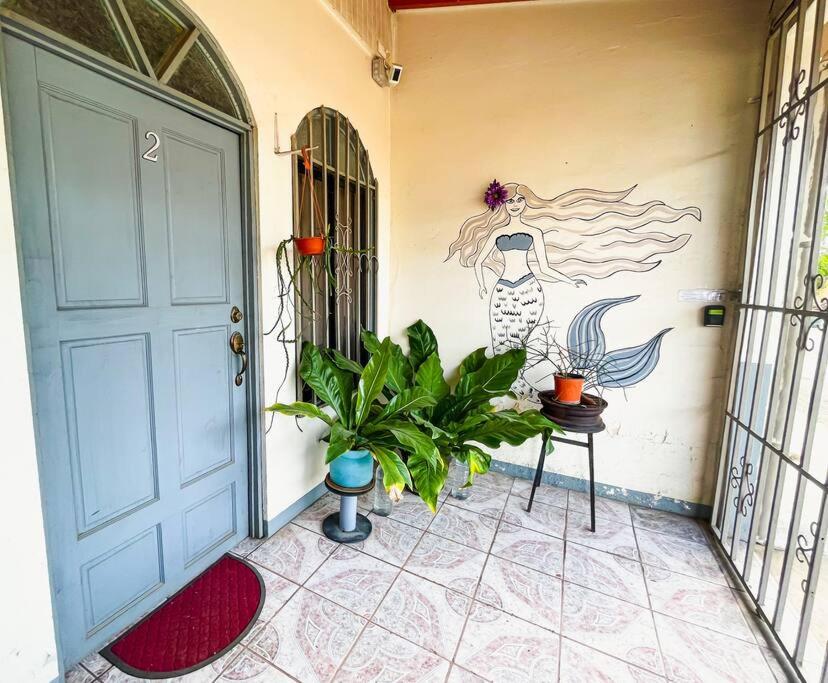 a room with a door and a plant and a painting at Escape to Pier Sands Casita#2- Close to the Beach. in Puntarenas