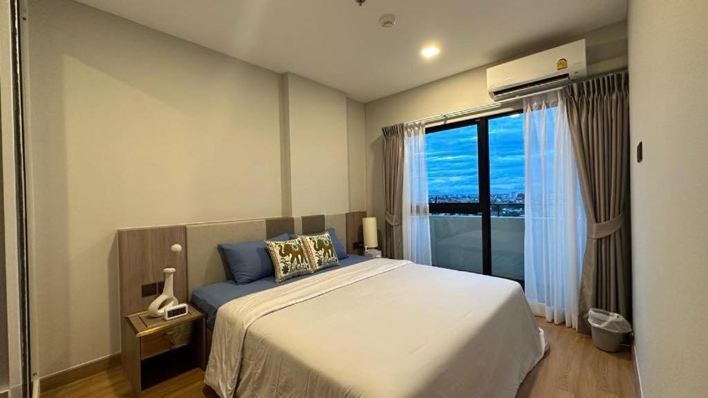 a bedroom with a large bed and a large window at Astra Sky River- Chiang Mai 1 in Chiang Mai