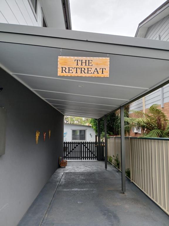 a building with a sign that reads the retreat at Our Retreat in Forster