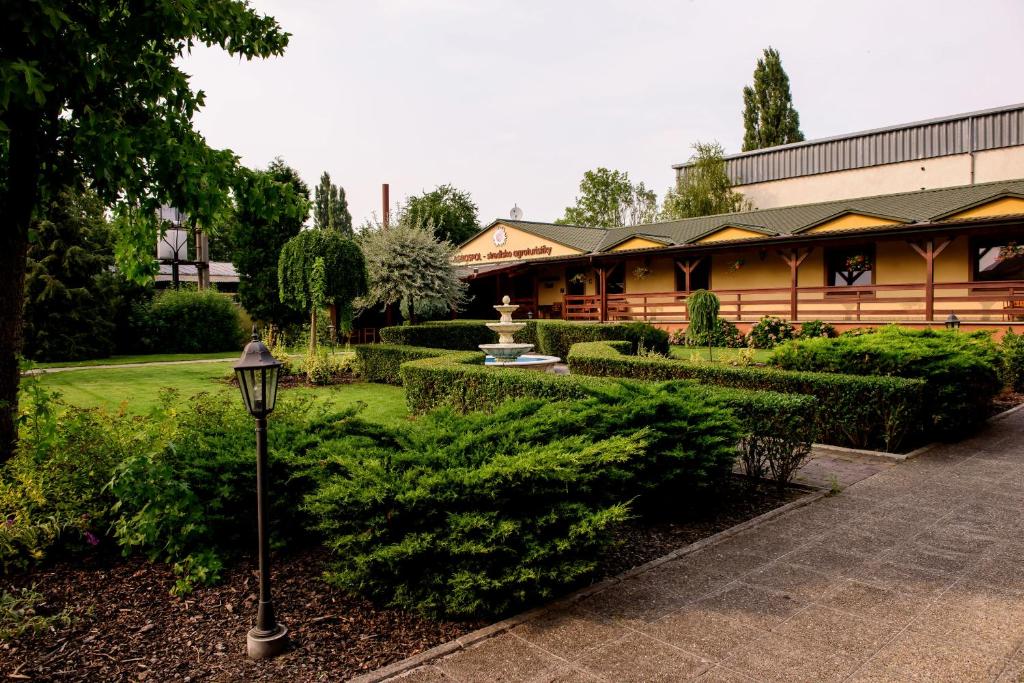 ein Gebäude mit einem Garten und einer Straßenbeleuchtung in der Unterkunft Hotel Slnecny Dvor in Michalovce