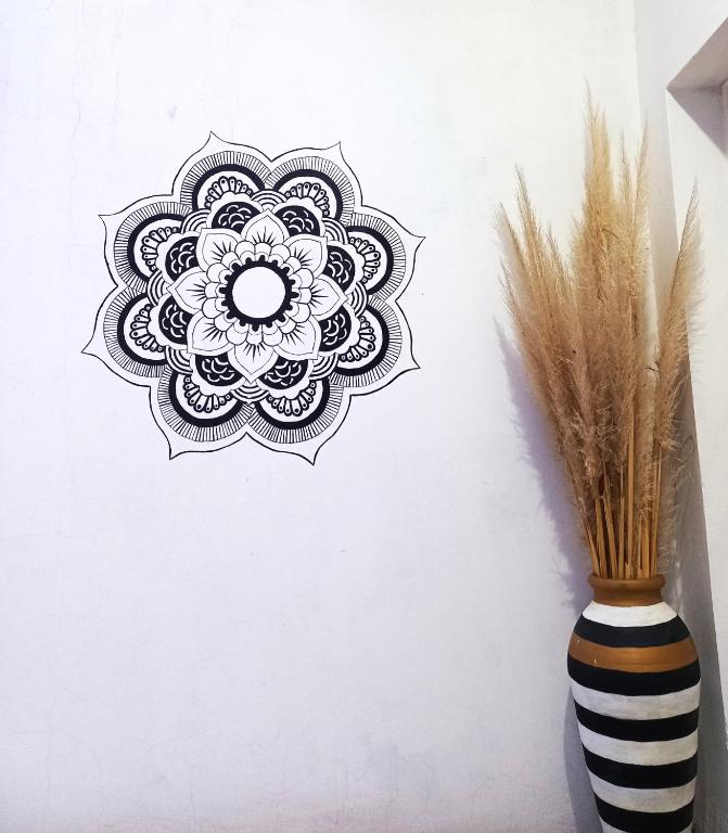 a black and white vase with a mandala on a wall at Departamento La Lita in Chilecito