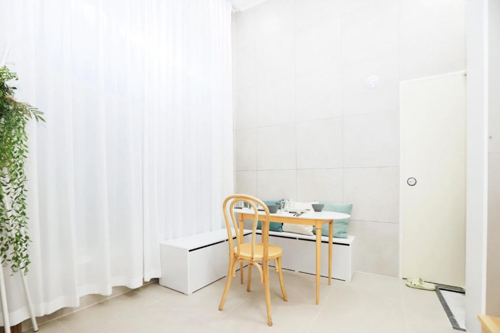 a table and chair in a room with a window at The Loft Homely in Seoul