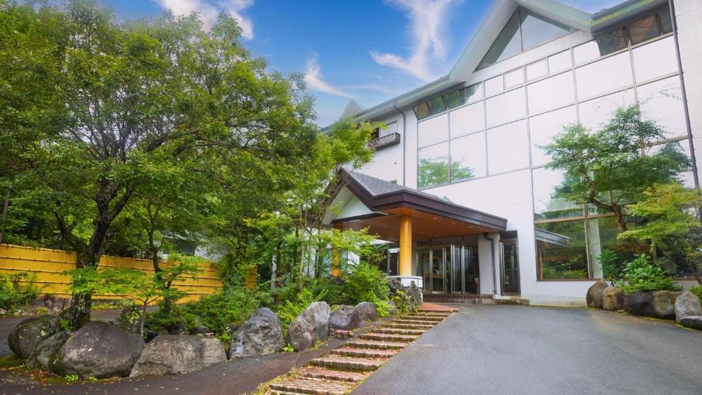a white building with rocks in front of it at Fuji Yamanakako Hotel in Yamanakako