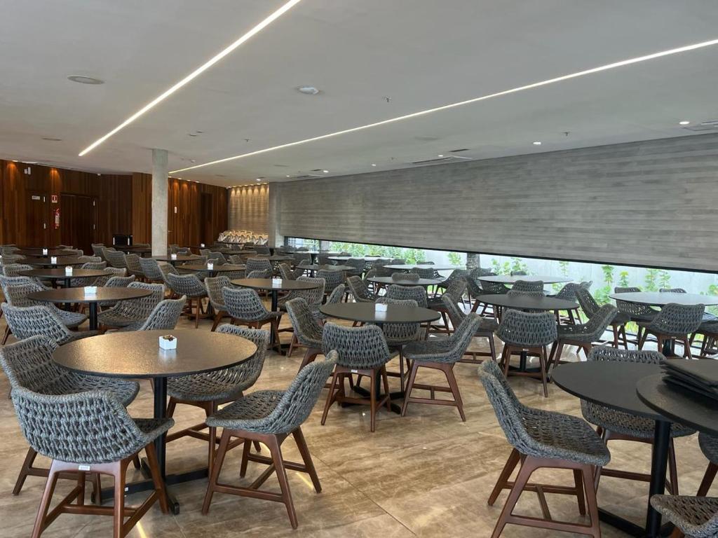un restaurante con mesas y sillas en una habitación en Salinas premium resort, en Salinópolis